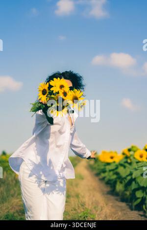 Eine junge Frau mit einem Blumenstrauß in einem weißen Hemd Stockfoto