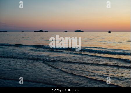 Sonnenuntergangswellen und ferne Inseln am Klong Prao Beach, Koh Chang Stockfoto