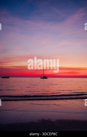 Rosa und lila Sonnenuntergang über dem ruhigen Meer mit Segelbooten auf Koh Chang Stockfoto