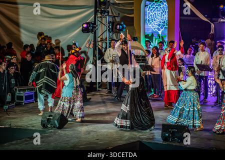 Oaxaca, Mexiko - 02. November 2023: Die pulsierende Bühnenvorstellung entfaltet sich mit Tänzern in traditionellen Kleidern und Musikern unter dem hellen Licht Stockfoto