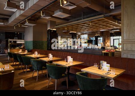 Modernes Restaurant mit Blick auf Tische und Barbereich Stockfoto
