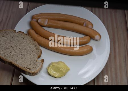 Große Wurst liegt auf einer Platte mit Brasse und Senf in Nahaufnahme Stockfoto