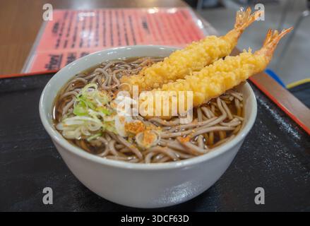 Eine große Schüssel Sobabudeln und Garnelentempura auf einem Tisch auf einem Fischmarkt in Hokkaido, Japan. Stockfoto