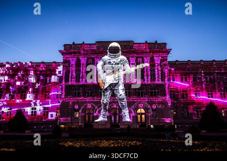 Zagreb, Kroatien - 16. März 2023: Blick auf das Mimara-Museum, getaucht in leuchtenden rosa und weißen Lichtprojektionen, scheint ein Astronautengitarrist zu spielen Stockfoto