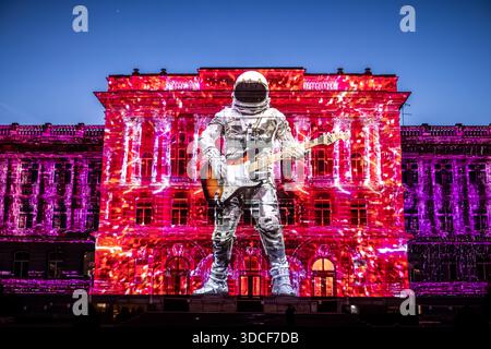 Zagreb, Kroatien - 16. März 2023: Blick auf eine Gebäudefassade, beleuchtet mit einer Projektion eines Astronauten, der eine Gitarre spielt, pulsierende Farben tanzen darüber Stockfoto