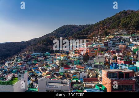Busan, Südkorea - 15. Dezember 2025: Blick auf die lebhaften, farbenfrohen Häuser des Gamcheon Culture Village, die unter klarem Blau den Hügel hinunterragen Stockfoto