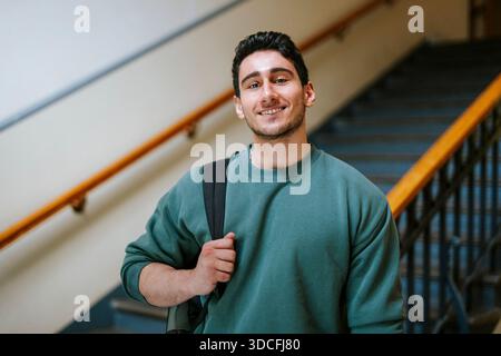 Porträt eines selbstbewussten männlichen Schülers, der mit Rucksack steht Stockfoto