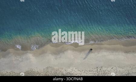 Aus der Vogelperspektive auf das kontrastfarbene türkisfarbene Meer trifft auf den Sandstrand von Maianbar, die Wellen küssen sanft das Ufer und schaffen eine ruhige Szene, Mai Stockfoto