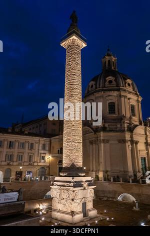 Die Trajansäule aus dem Jahr 113 n. Chr. im Trajan Forum (Foro di Traiano) wird bei Nacht in Rom beleuchtet. Antikes Wahrzeichen mit spiralförmigen Bas Stockfoto