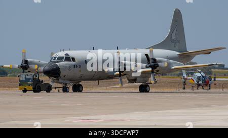 Moron, Spanien - 12. Mai 23: Ein militärisches P-3-Flugzeug auf einer Landebahn mit einem Hubschrauber im Hintergrund Stockfoto