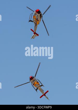 Moron, Spanien - 12. Mai 23: Zwei Patrulla ASPA Hubschrauber, die Luftmanöver gegen einen klaren blauen Himmel durchführen Stockfoto