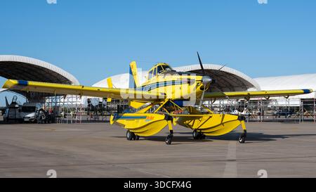 Moron, Spanien - 12. Mai 23: Ein hellgelbes Landwirtschaftsflugzeug AT-802A parkt auf einem Asphalt mit Hangars im Hintergrund Stockfoto