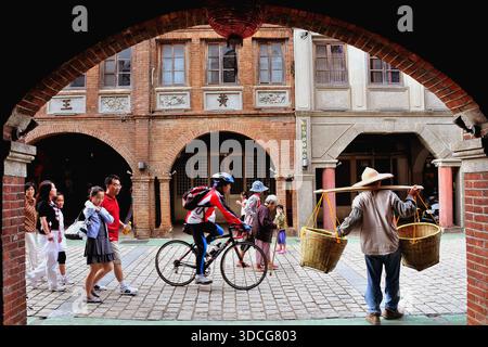 Historische Backsteinarchitektur in der Sanxia Old Street mit einem traditionellen Händler, der Bambuskörbe an einem Schultermast trägt, Taiwan. Stockfoto