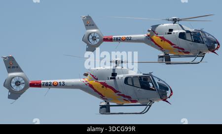 Moron, Spanien - 12. Mai 23: Zwei Patrulla ASPA Hubschrauber fliegen in Formation gegen einen klaren blauen Himmel Stockfoto