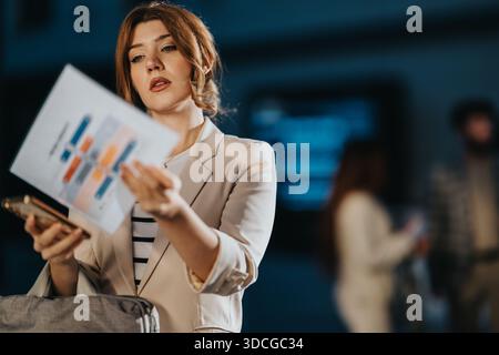 Frau präsentiert Kollegen während eines Geschäftstreffens in einem modernen Büro ein Diagramm Stockfoto