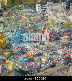 Aus der Vogelperspektive auf den lebhaften und geschäftigen Luna Park und Deno's Wonder Wheel Amusement Park, ein Kaleidoskop von Farben vor der Kulisse von Coney Islan Stockfoto