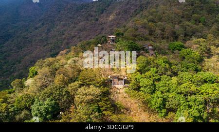 Blick aus der Vogelperspektive auf rustikale Häuser eingebettet zwischen grünem Laub, an den steilen Hängen mit Blick auf den Atitlan-See, San Marcos La Laguna, Sololá D Stockfoto