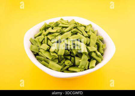 Grüne Bohnen. Schneiden Sie grüne Bohnen in eine Schüssel. Grüne Bohnen in weißer Schüssel Stock Foto Stockfoto