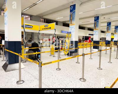 Manchester, Großbritannien - 13. Dezember 2025: Belebter Check-in-Bereich am Flughafen in Manchester mit gelben Barrieren, die die Passagiere leiten. Stockfoto