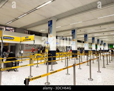 Manchester, Großbritannien - 13. Dezember 2025: Geschäftiges Terminal mit Warteschlangen und Passagieren am Flughafen Manchester. Stockfoto