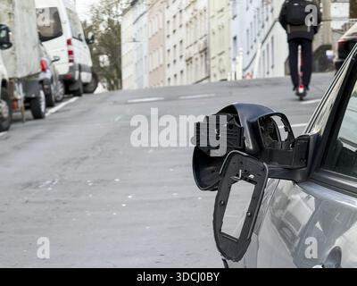 Ein Auto auf der Seite einer steilen Wohnstraße. Der linke Außenspiegel des Fahrzeugs ist stark beschädigt und ein Teil des Spiegels befindet sich auf der Motorhaube, Wuppertal, Stockfoto