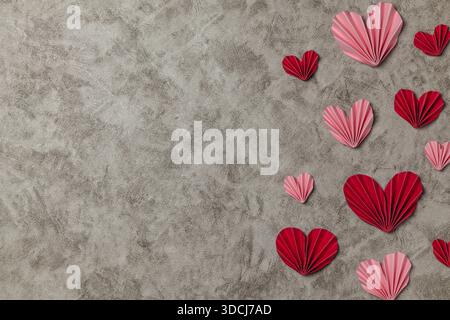 Flacher valentinstag-Hintergrund mit gefaltetem Papierherz. Flache Lay valentinshintergrund mit Kopierraum Stockfoto