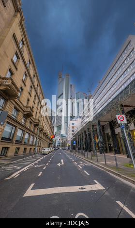 FRANKFURT a.M., DEUTSCHLAND, 12-07-2024, Blick durch eine Straßenschlucht in Frankfurt zum Commerzbank-Turm an einem bewölkten Tag. Stockfoto