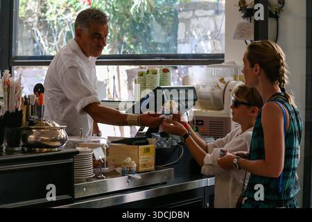 Gäste bestellen Eis und Getränke in einem kleinen Café auf der Insel Capri, einem beliebten Reiseziel in der Bucht von Neapel. Stockfoto