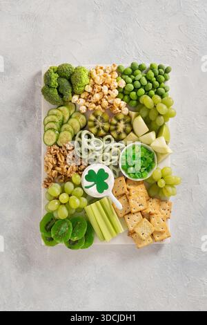 St. Patricks Day Charcuterie Board mit grünem Obst und Gemüse auf hellem Hintergrund. Blick von oben. Feierliche Vorspeise zum Feiern. Stockfoto