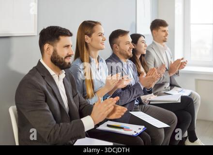 Gruppe von Geschäftsleuten, die bei Konferenzen oder Seminaren als Moderator auftreten und die Hände klatschen Stockfoto