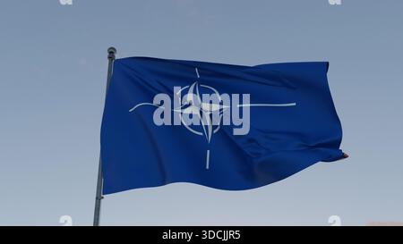 Schwenkende NATO-Flagge mit weißem Kompass-Emblem auf blauem Hintergrund vor klarem Himmel, symbolisiert Sicherheit, Verteidigung, Einheit und internationale Militärs Stockfoto