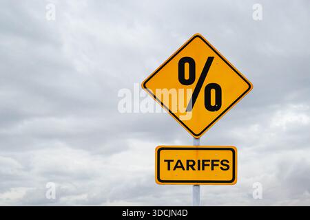 Tarife. Sanktionen und Zollerhöhungen, kreative Idee. Gelbes Gebührenschild auf grauem, bewölktem Himmel, Konzept. Stockfoto