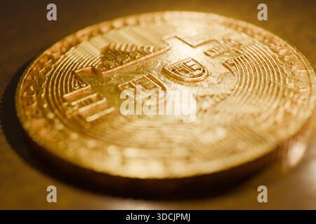 Nahaufnahme eines glänzenden goldenen Bitcoins, der auf einer reflektierenden Oberfläche liegt und Kryptowährung, digitales Geld, Blockchain-Technologie, Investitionen, und Mo Stockfoto