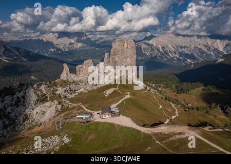 Aus der Vogelperspektive auf die zerklüfteten Gipfel von Cinque Torri, die in den Himmel ragen, inmitten eines Wandteppichs aus grünen Wiesen und zerklüftetem Gelände, Venetien, Italien. Stockfoto