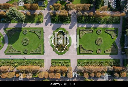 Der Blick aus der Vogelperspektive auf gepflegte Gärten mit symmetrischen Mustern und ein zentraler Brunnen schaffen eine ruhige Oase in Wien, Wien, Österreich. Stockfoto