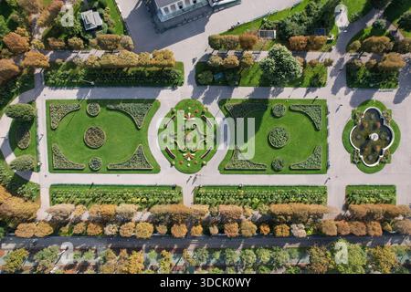 Blick aus der Vogelperspektive auf gepflegte Gärten mit symmetrischen Mustern und lebendigen grünen Rasenflächen, die eine atemberaubende geometrische Darstellung schaffen, Wien, Österreich. Stockfoto
