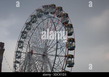 Nahaufnahme des mehrfarbigen Riesenrads während Dussehra Mela in Delhi, Indien. Unteransicht des Riesenradschwenkens. Riesenrad mit farbenfrohen Kabinen durin Stockfoto