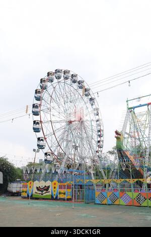 Nahaufnahme des mehrfarbigen Riesenrads während Dussehra Mela in Delhi, Indien. Unteransicht des Riesenradschwenkens. Riesenrad mit farbenfrohen Kabinen durin Stockfoto