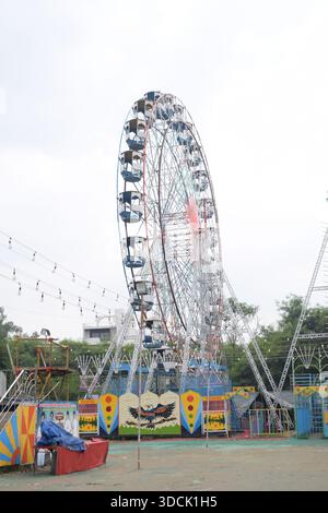Nahaufnahme des mehrfarbigen Riesenrads während Dussehra Mela in Delhi, Indien. Unteransicht des Riesenradschwenkens. Riesenrad mit farbenfrohen Kabinen durin Stockfoto