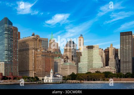 Ein heller Blick auf die Skyline von Downtown Manhattan und das elegante Pier A Harbor House im Vordergrund der dichten Türme des Finanzviertels. Stockfoto