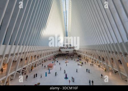 Pendler und Käufer bewegen sich durch die riesige Marmorhalle des Oculus am World Trade Center Transportation Hub in New York City Stockfoto