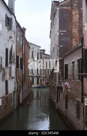 Reisen Sie italien venedig schmaler Kanal, der sich durch alte Architektur schlängelt und das tägliche Leben in venedig zeigt Stockfoto