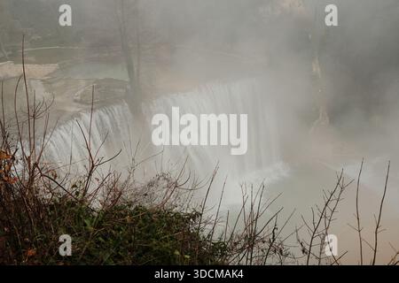 Mächtiger Wasserfall versteckt in dickem Morgennebel in der Nähe von Jajce, Bosnien und Herzegowina. Natürliche Energie, frische Luft und dramatischer Wasserfluss sorgen für Ruhe Stockfoto