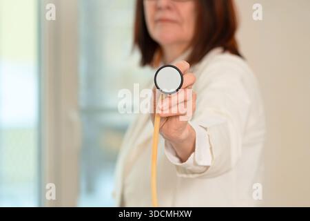 Nahaufnahme eines erfahrenen Arztes in weißer Uniform mit Stethoskopdiaphragma. Schwerpunkt auf Atemdiagnostik, Lungenentzündung, Bronchitis und Patientenversorgung im klinischen Umfeld. Stockfoto