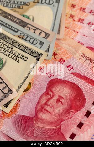 Rotes chinesisches Bargeld in Stückelungen von hundert Yuan und amerikanischen Dollar, Papiergeld von amerikanischem und chinesischem Geld, chinesische Banknoten von 100 Yuan Stockfoto