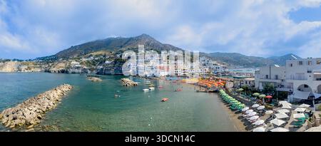 Panoramablick auf den Hafen von Sant’Angelo mit farbenfrohen Sonnenschirmen und Booten in Ischia, Kampanien, Italien. Stockfoto