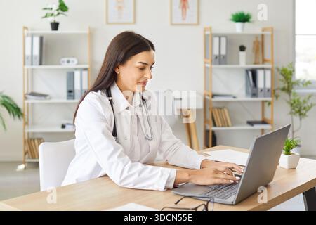 Ärztin oder Krankenschwester, die im Krankenhausbüro an Einem Laptop arbeitet Stockfoto