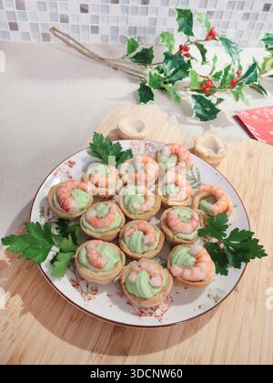 Kalte Vorspeise für Feiertagstisch. Mürbteigkörbe mit Garnelen-, Frischkäse- und Spinatfüllung. Hausgemachte gesunde Meeresfrüchte. Stockfoto