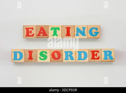 Gemalte Alphabetblöcke, die Essensstörung buchstabieren, auf weißem Hintergrund Stockfoto