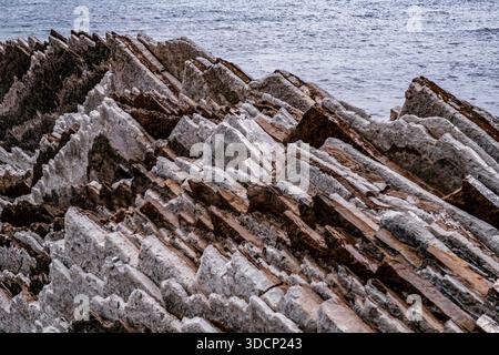 Zerklüftete Flysch Rock Formationen treffen auf den Atlantischen Ozean am Strand, Zumaia, Baskenland Stockfoto